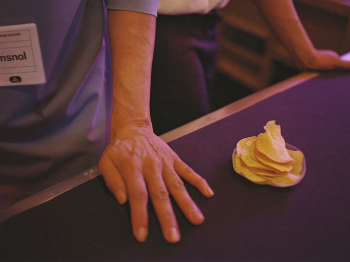 A guest's hand resting on a table rail beside a stack of chips