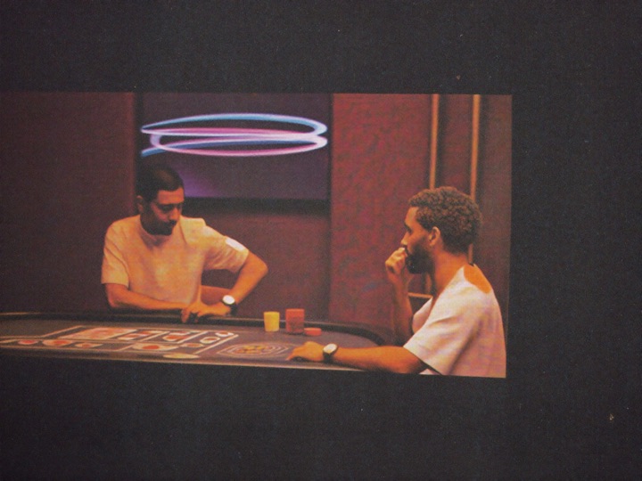 A quiet private members room with two guests at a single baccarat table